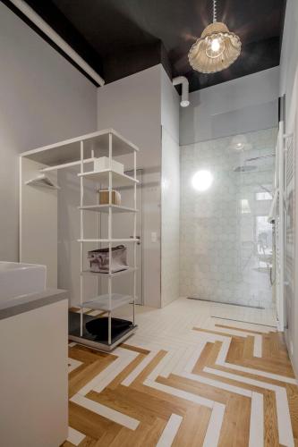 a bathroom with white walls and a floor with a shower at grätzlhotel Karmelitermarkt in Vienna