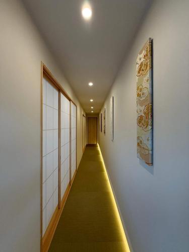 a long hallway with a yellow carpet in a building at b hotel Miyajima Omotesando - Sacred Island Stay 32 in Miyajima