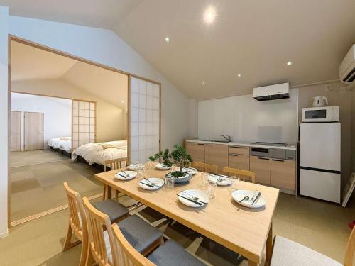 a kitchen and dining room with a wooden table and chairs at b hotel Miyajima Omotesando - Sacred Island Stay 32 in Miyajima