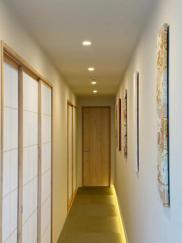 a hallway with a wooden door and a hallwayngth at b hotel Miyajima Omotesando - Sacred Island Stay 32 in Miyajima
