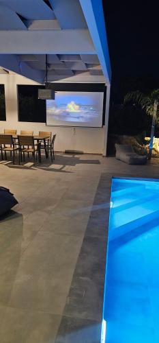 a view of a swimming pool with a tv in a house at Luxurious Villas Rocca Blanco 1 & 2 in Kounoupidhianá