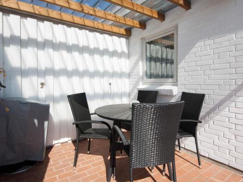 a table and chairs on a patio with a window at 4 person holiday home in Gråsten-By Traum in Gråsten