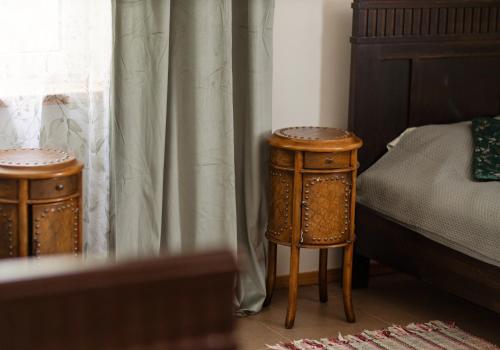 a bedroom with two wooden stools next to a bed at ``Art home Baroni`` in Cēsis