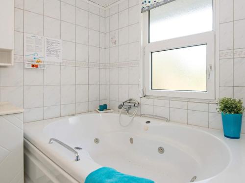 a white bath tub in a bathroom with a window at 6 person holiday home in Hejls in Hejls