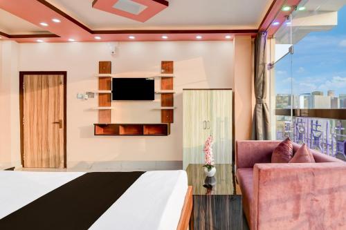 a room with a bed and a tv and a chair at Super Hotel O Kakdwip in Kākdwīp