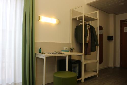 a dressing room with a desk and a green stool at Hotel Embassy in Pero