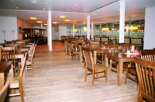 comedor con mesas y sillas de madera en Tukuma Ledus Halle, en Tukums