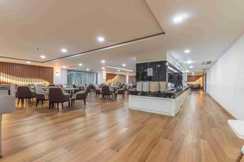 a restaurant with tables and chairs in a room at Elong WG international hotel艺龙万国酒店 in Jomtien Beach
