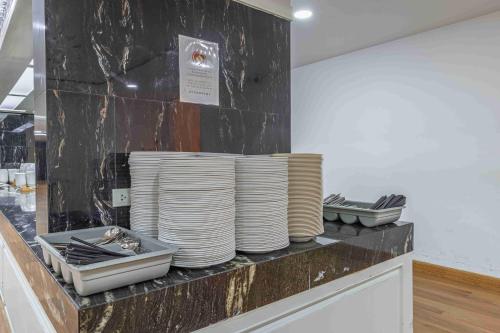 a pile of plates sitting on top of a counter at Elong WG international hotel艺龙万国酒店 in Jomtien Beach