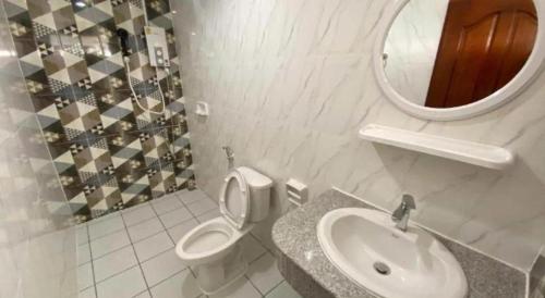 a bathroom with a toilet and a sink and a mirror at Hihotel Saraburi in Sara Buri