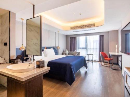 a hotel room with a bed and a sink at Yitel Collection Lianyungang High-speed Railway Station Suning Plaza in Lianyungang