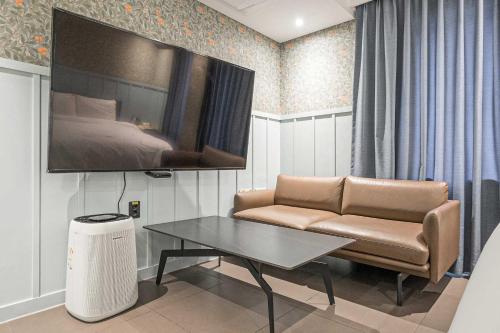 a living room with a couch and a bed at Aloha Hotel in Hanam