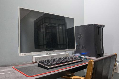 a computer monitor and keyboard on a desk at Aloha Hotel in Hanam