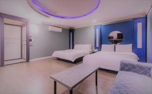 a hotel room with two beds and a table at Hotel Head-One in Uijeongbu