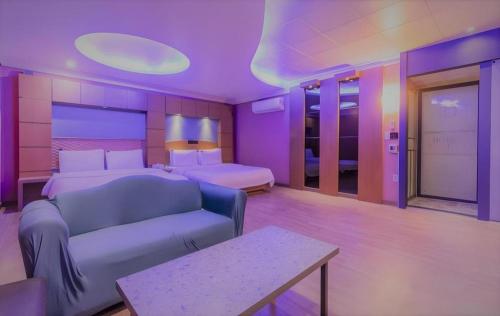 a purple room with a bed and a couch at Hotel Head-One in Uijeongbu