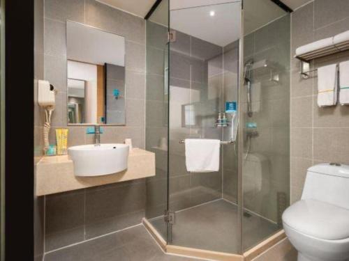 a bathroom with a shower and a toilet and a sink at City Comfort Inn Wuhan Hanyang Street Caidian Square Metro Station in Wuhan