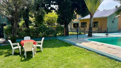 a table and chairs in a yard next to a pool at Runako Lodge in Arusha