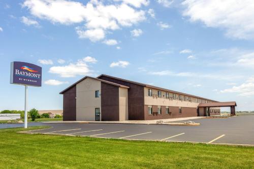 オシュコシュにあるBaymont by Wyndham Oshkosh Airportの駐車場の前に看板がある建物