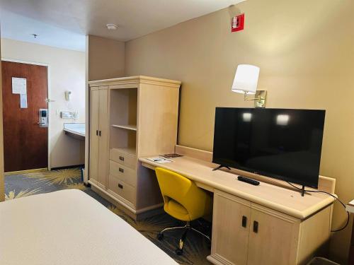 a room with a desk with a flat screen tv at Days Inn by Wyndham Seatac Airport in SeaTac