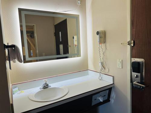 a bathroom with a sink and a mirror at Days Inn by Wyndham Seatac Airport in SeaTac
