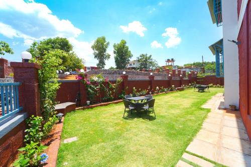 a garden with a table and chairs in a yard at RedRock Villa in Mahabaleshwar