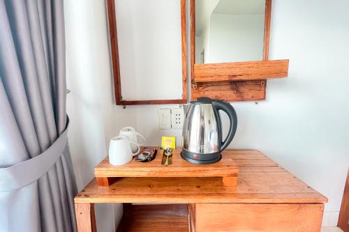 una cafetera sobre una mesa de madera en una habitación en Toba Crest Vue By Helocus, en Parapat