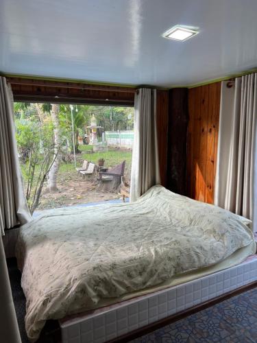 a bed in a room with a large window at Baan Nara Homestay - Koh Kood in Ko Kood