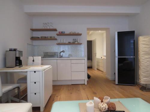 a kitchen with white cabinets and a black refrigerator at Apartments Spittelberg Gardegasse in Vienna