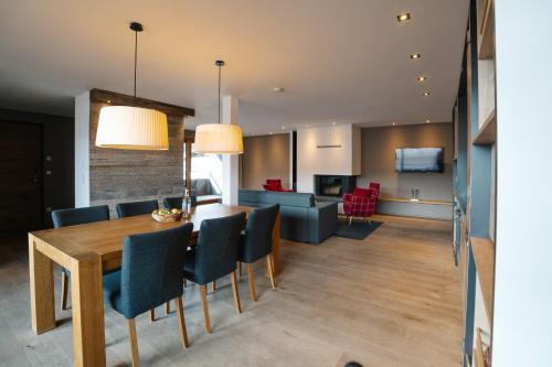 a dining room and living room with a table and chairs at Das.Hochgrat in Oberstaufen