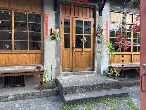 a building with a wooden door and two benches at 月光寶盒旅店 Moonlight Hostel in Kaohsiung