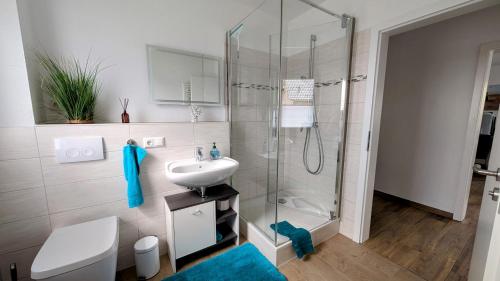 ルブミンにあるFerienwohnung Strandliebeのガラスのシャワーと洗面台を備えたバスルーム