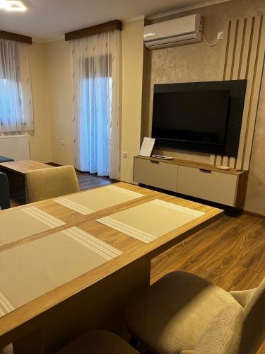 a room with a table with a flat screen tv at Casa Due in Novi Sad