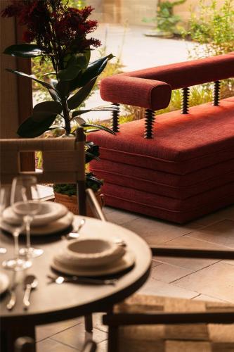a table with plates on top of a table with a chair at Palacio De Godoy Caceres, Curio Collection By Hilton in Cáceres