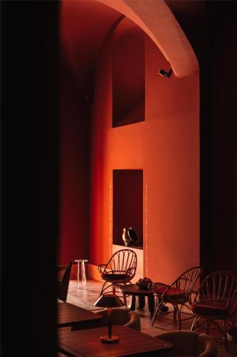 a room with chairs and a table and a red wall at Palacio De Godoy Caceres, Curio Collection By Hilton in Cáceres
