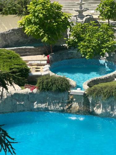 a swimming pool with blue water in a garden at Brilliance in Varna City