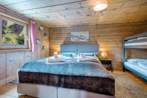 a bedroom with a bed in a wooden room at BERGCHALET VALLUGA in Steeg