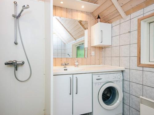 a bathroom with a washing machine and a sink at Eco-Friendly Retreat with Spa - By Traum Ferienwohnungen in Blåvand