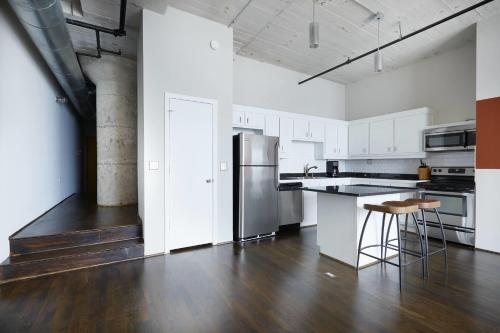 a kitchen with white cabinets and a stainless steel refrigerator at Reside Houston Downtown, a Wyndham Residence in Houston