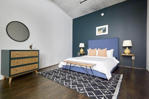a bedroom with a large bed and a blue wall at Reside Houston Downtown, a Wyndham Residence in Houston