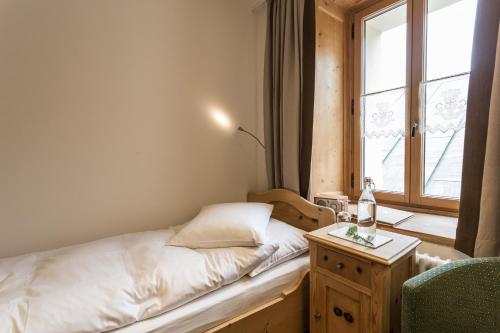 a small bedroom with a bed and a window at Meisser Hotel "superior" in Guarda