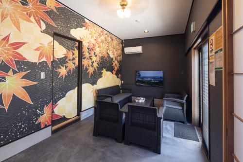 a waiting room with chairs and a wall mural at A home ゲストハウスすえ in Mashizume