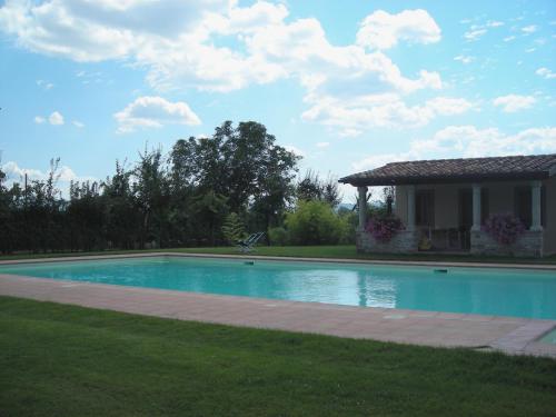 a swimming pool in a yard with a house at Agriturismo Il Trebbio in Sansepolcro