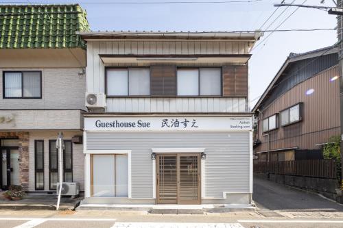 a building with a sign for a store at A home ゲストハウスすえ in Mashizume