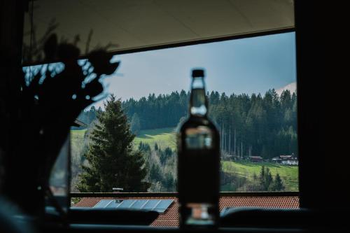 a bottle of wine sitting in front of a window at Das.Hochgrat in Oberstaufen