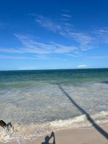 a shadow of a person in the water on the beach at Mzimu guest house with ocean views in Nkunjila