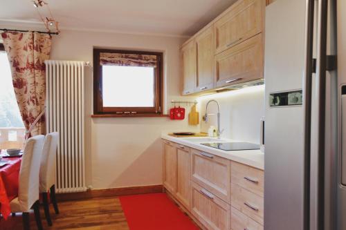 a kitchen with wooden cabinets and a white refrigerator at Maison Carrel Elegant 4 in Breuil-Cervinia