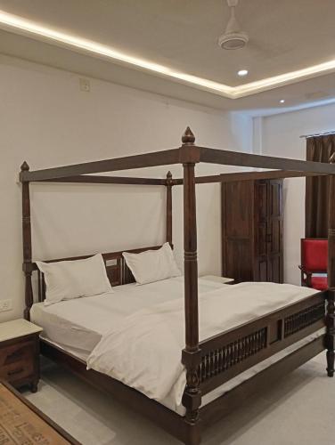 a bed with a wooden frame in a room at Hotel Har Niwas udaipur city of lakes in Udaipur
