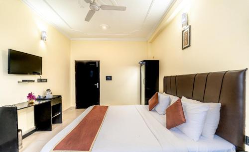 a bedroom with a large bed and a television at Flutter Hotels & Resort in Lansdowne