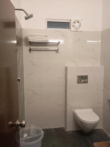 a bathroom with a toilet and a window at Hotel Har Niwas udaipur city of lakes in Udaipur