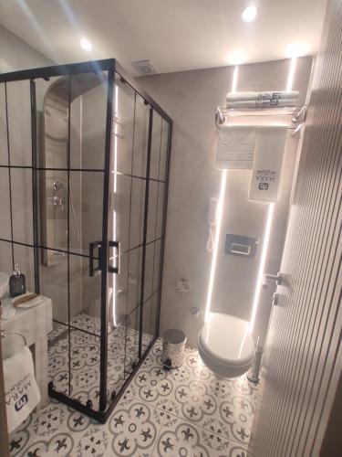 a bathroom with a shower and a toilet with lights at Mara Oldcity Hotel in Istanbul